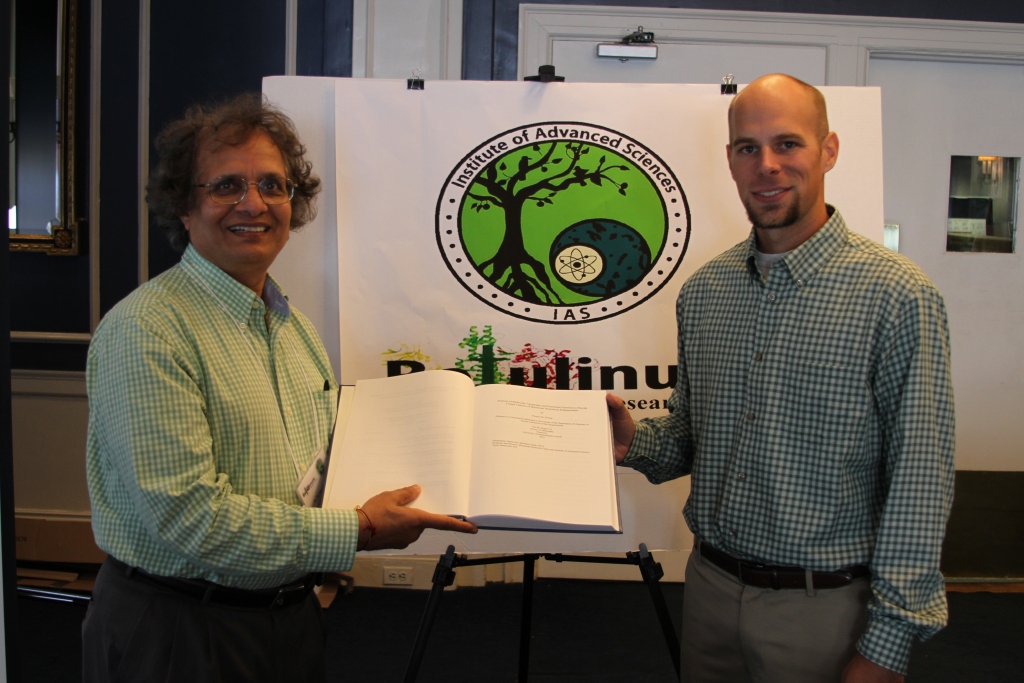 Dr. Tom Feltrup presenting a copy of his thesis to Dr. Singh